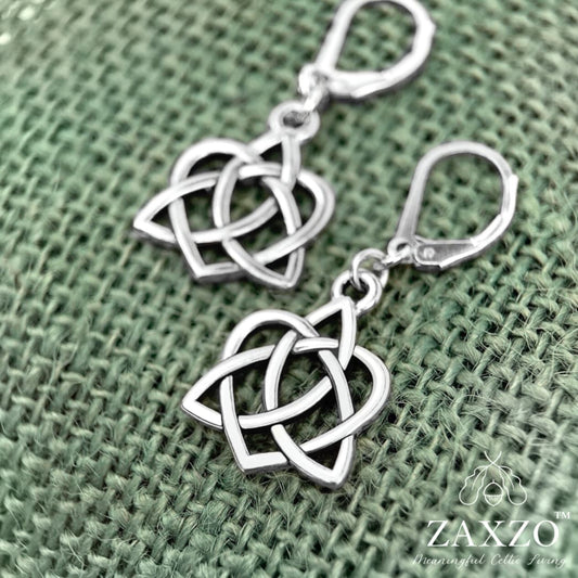 Silver celtic heart interwoven with trinity knot on lever back ear wire shown on sage green burlap.